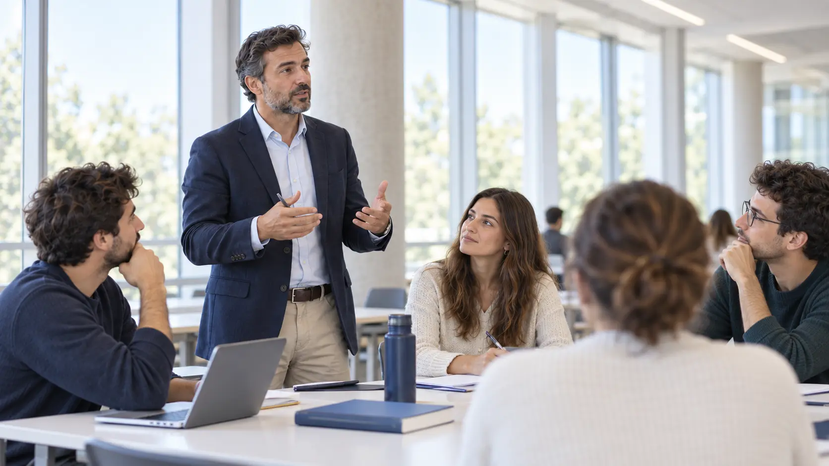 Docente conversando con alumnos adultos en un aula